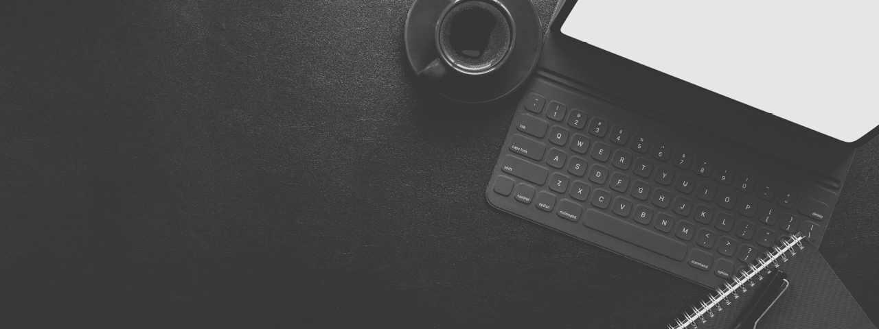 Schwarz-weißes Bild eines Laptops und einer Espressotasse