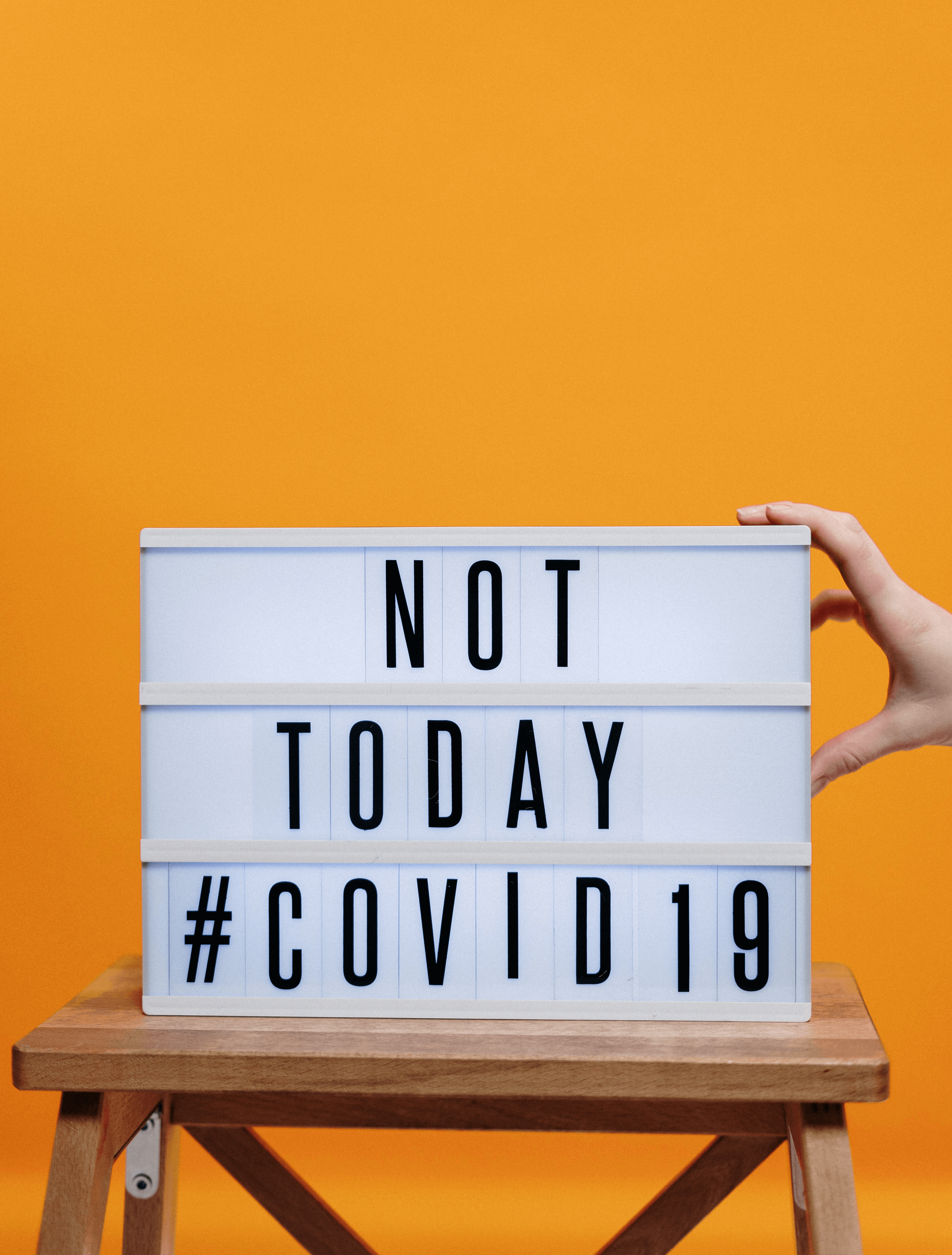 Retro-Leuchtbox mit der Aufschrift "Not today #covid19" vor orangenem Hintergrund